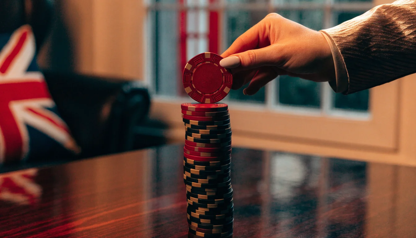 Casino chips being topped up on a mahogany table with British elements in the background.